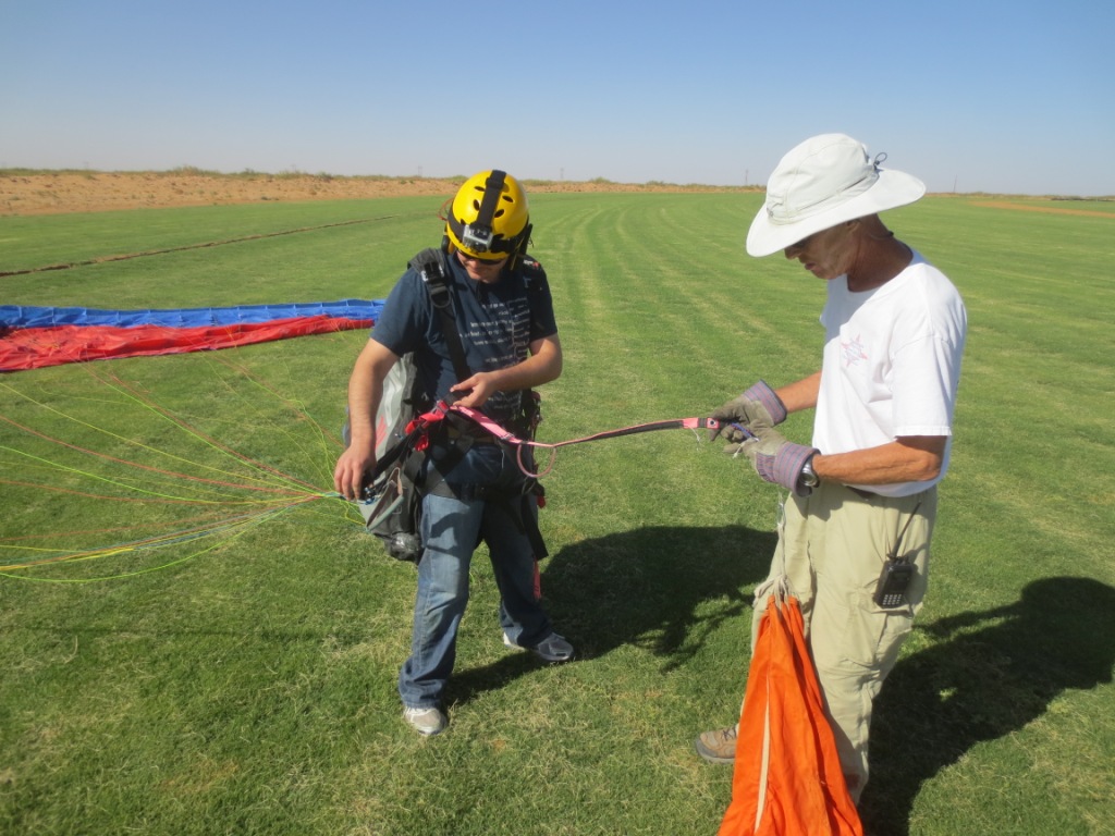 paraglider pilot hooking up to the tow line